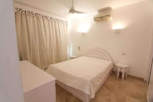 a bedroom with a white bed in a room at El Gouna spacious flat in Steigenberger Golf in Hurghada