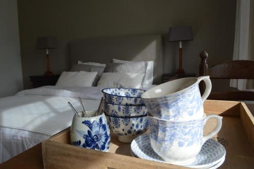 a wooden box with three blue and white vases on a bed at Huis aan Honte in Dishoek
