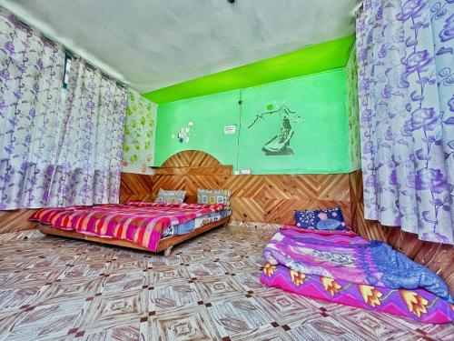 two beds in a room with purple and green at Memoir Homestay in Kasol