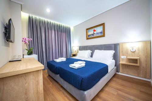 ein Hotelzimmer mit einem Bett mit Handtüchern darauf in der Unterkunft CLASS Hotel in Ksamil