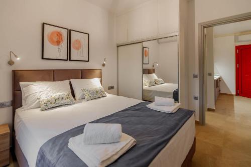 a bedroom with a large bed with two towels on it at Natura Luxury Suites Parga in Parga