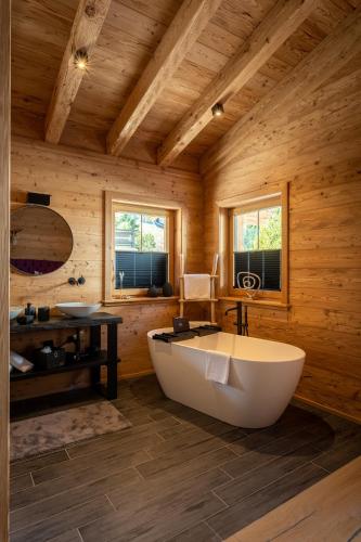 a large wooden bathroom with a tub and a sink at Mountain Chalet R in Berwang