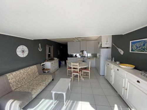 un salon avec un canapé et une cuisine dans l'établissement 2 pièces avec terrasse et parking à Port Camargue - 6 couchages, appontement inclus - FR-1-250-231, au Grau-du-Roi