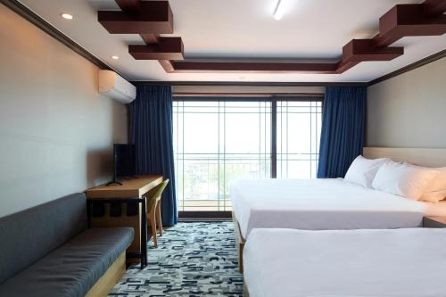 A bed or beds in a room at Sokcho Good Morning Hotel and Resort