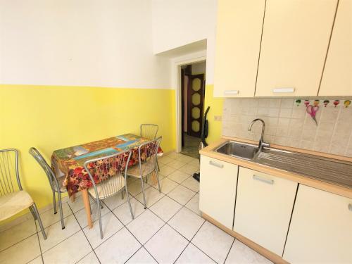 a kitchen with a table with chairs and a sink at Appartamento Pilloa in La Spezia