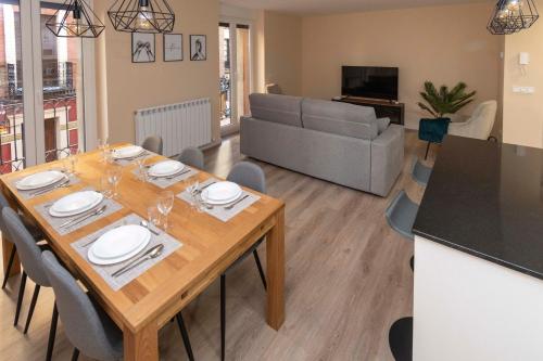 a dining room and living room with a table and chairs at Espectacular piso en casco histórico-plaza Don Gutierre in León