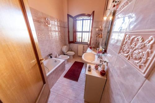 uma casa de banho com uma banheira, um WC e um lavatório. em Ilice em Zafferana Etnea