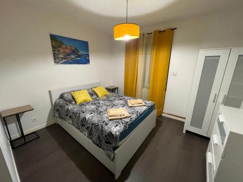 een slaapkamer met een bed met 2 gele kussens bij Red lights grand appartement in Saint-Étienne