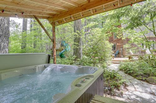a hot tub in the middle of a backyard with a wooden roof at River Breeze Chalet - Meredith Lodging in Rhododendron