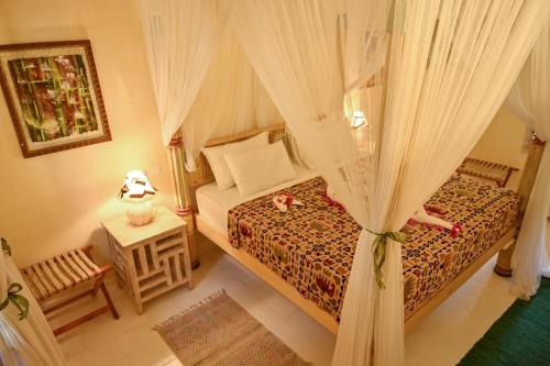 a bedroom with a bed with a canopy at Lions' Luxury Eco Resort & Spa in Malindi