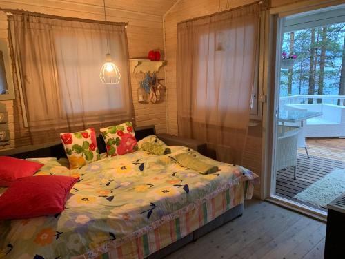 a bedroom with a bed and a sliding glass door at Loistava Aurinkoranta Mökki in Ähtäri