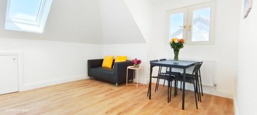 a living room with a table and a couch at Phlox Garden in Sutton