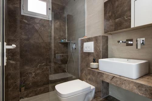 a bathroom with a toilet and a sink and a shower at Studios Halkia in Toroni