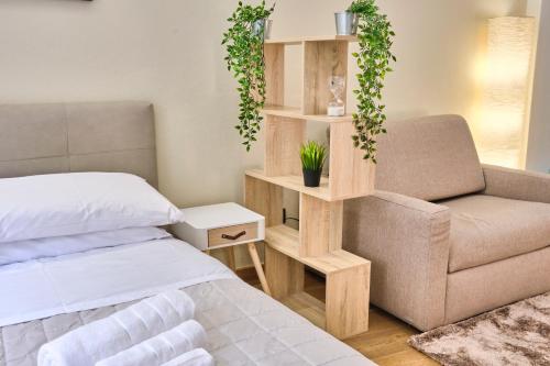 a bedroom with a bed and a chair and a book shelf at [CENTRO-LECCO] Romantico Appartamento sul Lago in Lecco