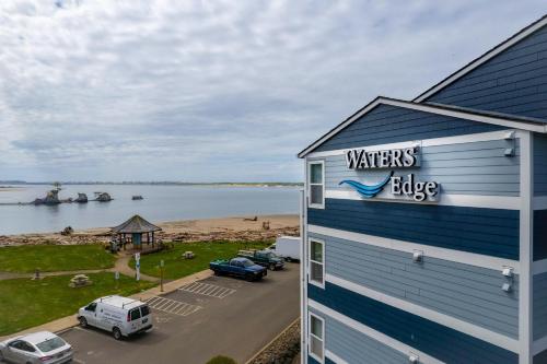 a building with a sign on it next to a body of water at Waters Edge 207 in Lincoln City