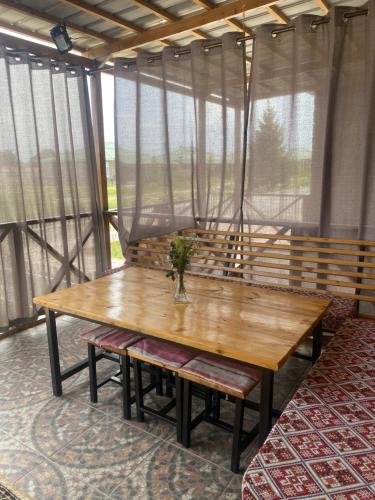 a wooden table in a room with windows at Коттедж в ЦО Париж in Chok-Tal