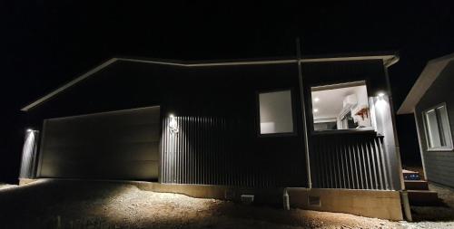 a building with a garage door with a window at night at Boujee in Lake Tekapo