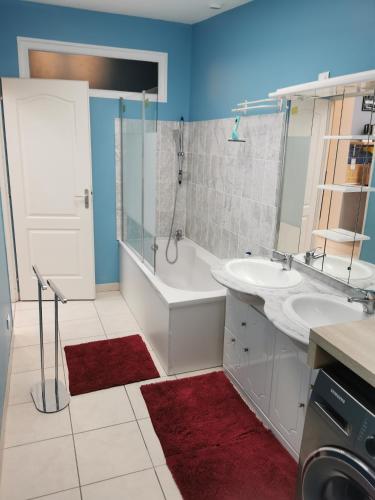 une salle de bain avec deux lavabos, une baignoire et une douche dans l'établissement Agréable maison de 100m2 avec son parking privatif, à Calais