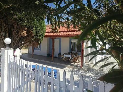 a white fence in front of a white house at Porto Almira Beachfront House in Nikiti