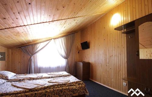 Habitación de hotel con cama y ventana en САДИБА та ЧАН "NA PAGORBI" en Yaremcha