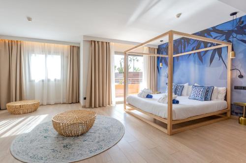 1 dormitorio con cama con dosel y mesa en Marins Beach Club - Adults Only Hotel en Cala Millor