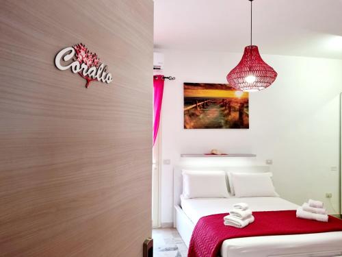 a bedroom with a bed with a red blanket at Albatros B&B Porto Cesareo in Porto Cesareo