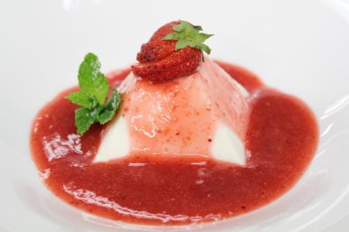 a dessert with a strawberry and sauce on a white plate at Hotel Maison Saint Jean in Courmayeur