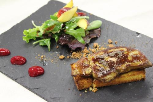 a black plate with a sandwich and a salad at Hotel Maison Saint Jean in Courmayeur