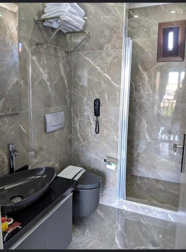 a bathroom with a sink and a toilet and a shower at Venus Hotel in Pamukkale