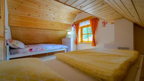 two beds in a room with a wooden ceiling at Holiday House Pečišće in Skrad