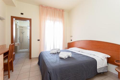 a bedroom with a bed with two towels on it at HOTEL VILLA MARIA in Cesenatico
