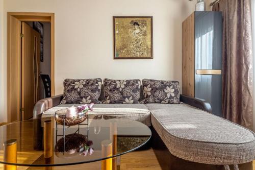 a living room with a couch and a glass table at Tourist Apartment in Klaipėda