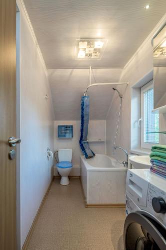 a bathroom with a toilet and a tub and a sink at Tourist Apartment in Klaipėda