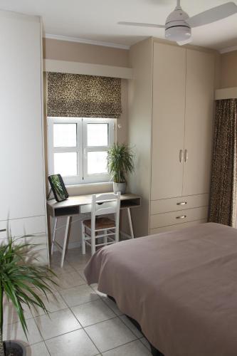 1 dormitorio con cama, escritorio y mesa en Asteri Apartments Mytikas 2-Bedroom Seaview Courtyard en Mýtikas