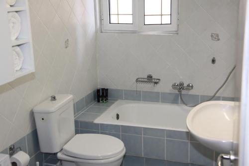 e bagno con servizi igienici, vasca e lavandino. di Asteri Apartments Mytikas 2-Bedroom Seaview Courtyard a Mýtikas