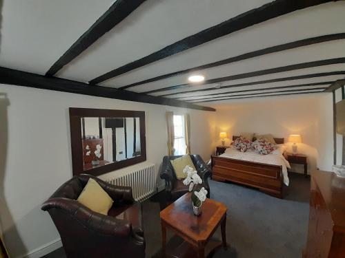 a living room with a bed and chairs and a table at Stone Court House in Maidstone