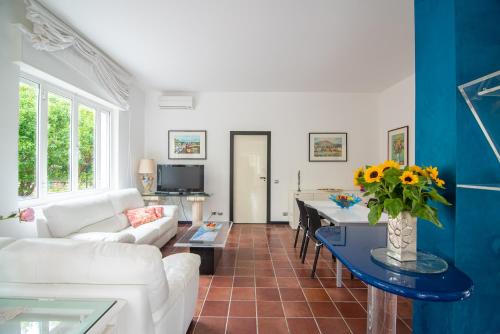 a living room with a white couch and a table with flowers at Magnificent Villa Sanremo in Sanremo