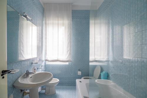 a blue bathroom with a sink and a toilet at Magnificent Villa Sanremo in Sanremo