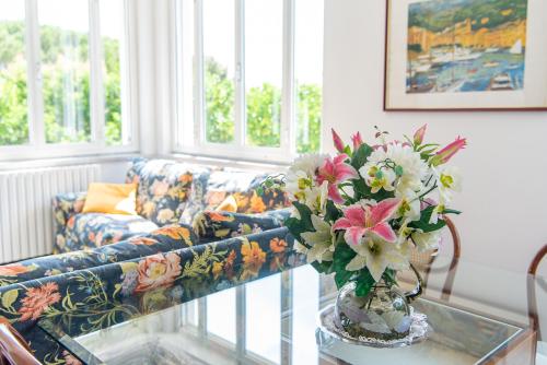 a living room with a couch and a vase of flowers at Magnificent Villa Sanremo in Sanremo