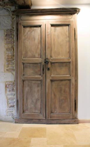a wooden door in the corner of a room at LE CLOS DES PIERRES ROUGES in Burgy