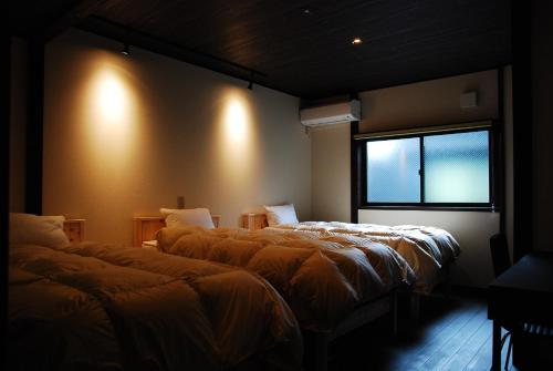 Habitación con 3 camas y ventana en Kanazawa Hitomuneyado Kaisen - Vacation STAY 94227v en Kanazawa