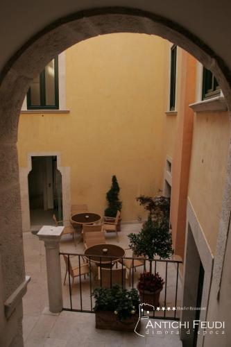 an archway with tables and chairs in a courtyard at Antichi Feudi Dimora D'Epoca in Teggiano