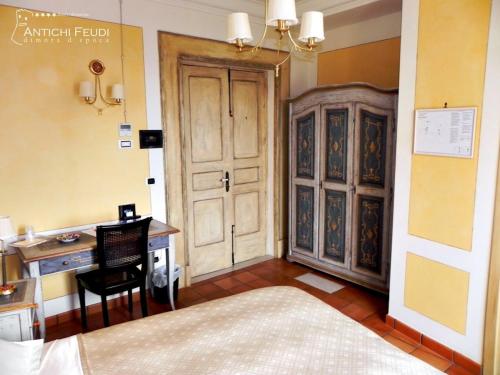 a room with a bedroom with a desk and a bed at Antichi Feudi Dimora D'Epoca in Teggiano