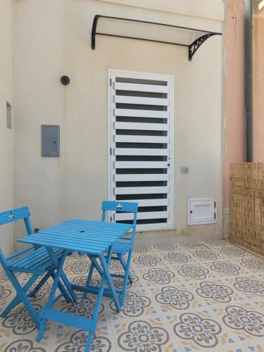 a blue table and two chairs on a tile floor at Casa del Borgo in Marzamemi