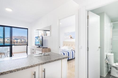ein Bad mit einem Waschbecken und einem WC sowie ein Schlafzimmer in der Unterkunft Trinisoll II 6-C Sea views Apartment Levante Beach in Benidorm