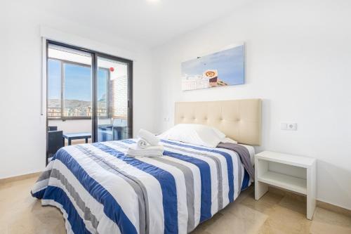 ein weißes Schlafzimmer mit einem Bett und einem Fenster in der Unterkunft Trinisoll II 6-C Sea views Apartment Levante Beach in Benidorm