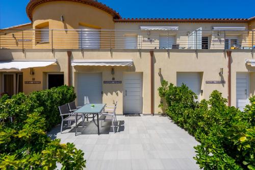 a patio with a table and chairs in front of a building at La Vida Sin Limites EMP in Empuriabrava