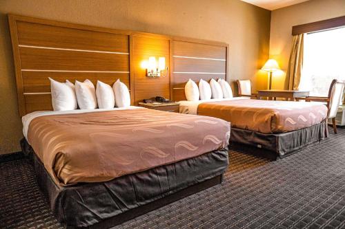 a hotel room with two beds in a room at Quality Inn & Suites near Six Flags - Austell in Austell