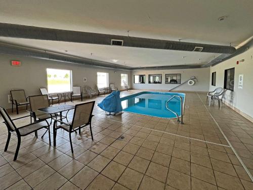 una piscina en una habitación con mesa y sillas en Comfort Suites Jackson-Cape Girardeau, en Jackson