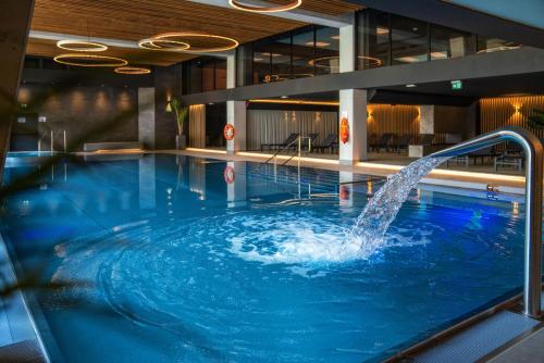 a swimming pool with a fountain in a building at Meta Apartments in Szczyrk